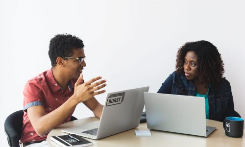 man-and-woman-brainstorming-with-laptops-min